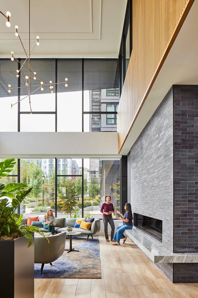 photo of the interior of broadstone strata with people gathered casually in the lobby near a fireplace