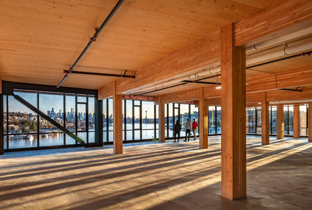 photo of the mass timber interior at northalke commons with people looking out the floor to ceiling windows with lake union and the seattle skyline