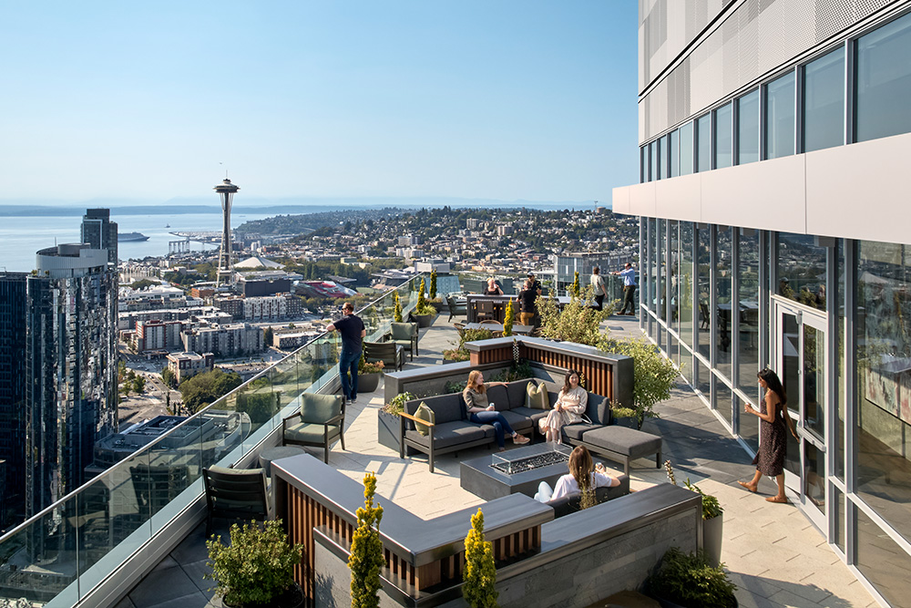 drone photo of the rooftop of the ayer with the space needle and seattle skyline in the background