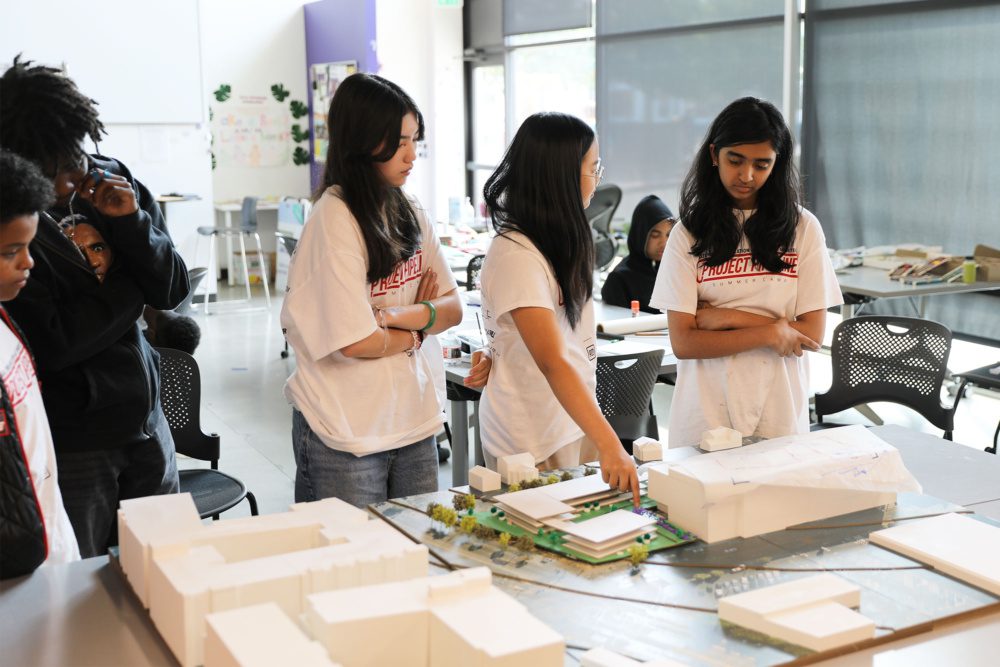 Photo of students looking at a model of the neighborhood