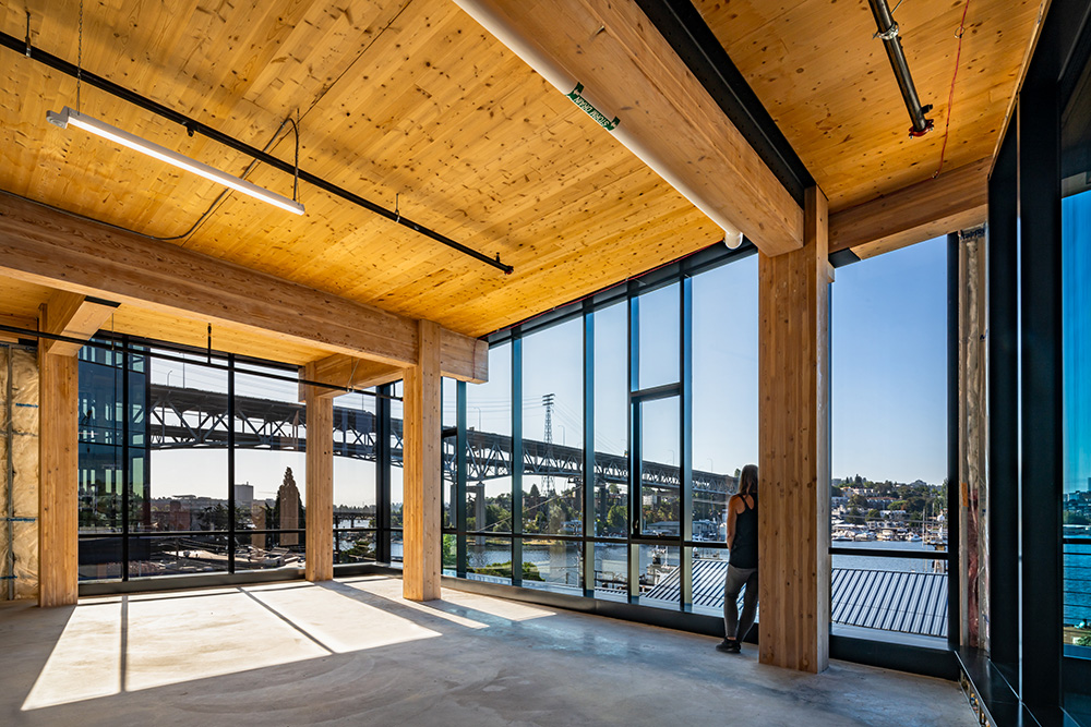 photo of the mass timber interior of northlake commons with a girl looking out the window and sun shining through