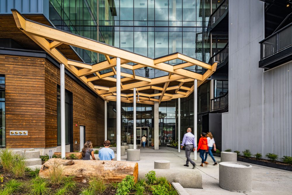 photo of the entrance of 35 stone with people walking under a timber design pergola 