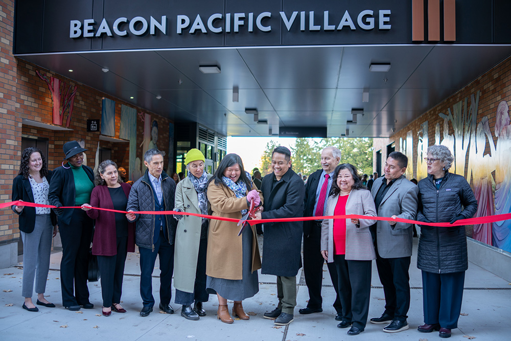 photo of the beacon pacific village team at the ribbon cutting ceremony cutting the ribbon together