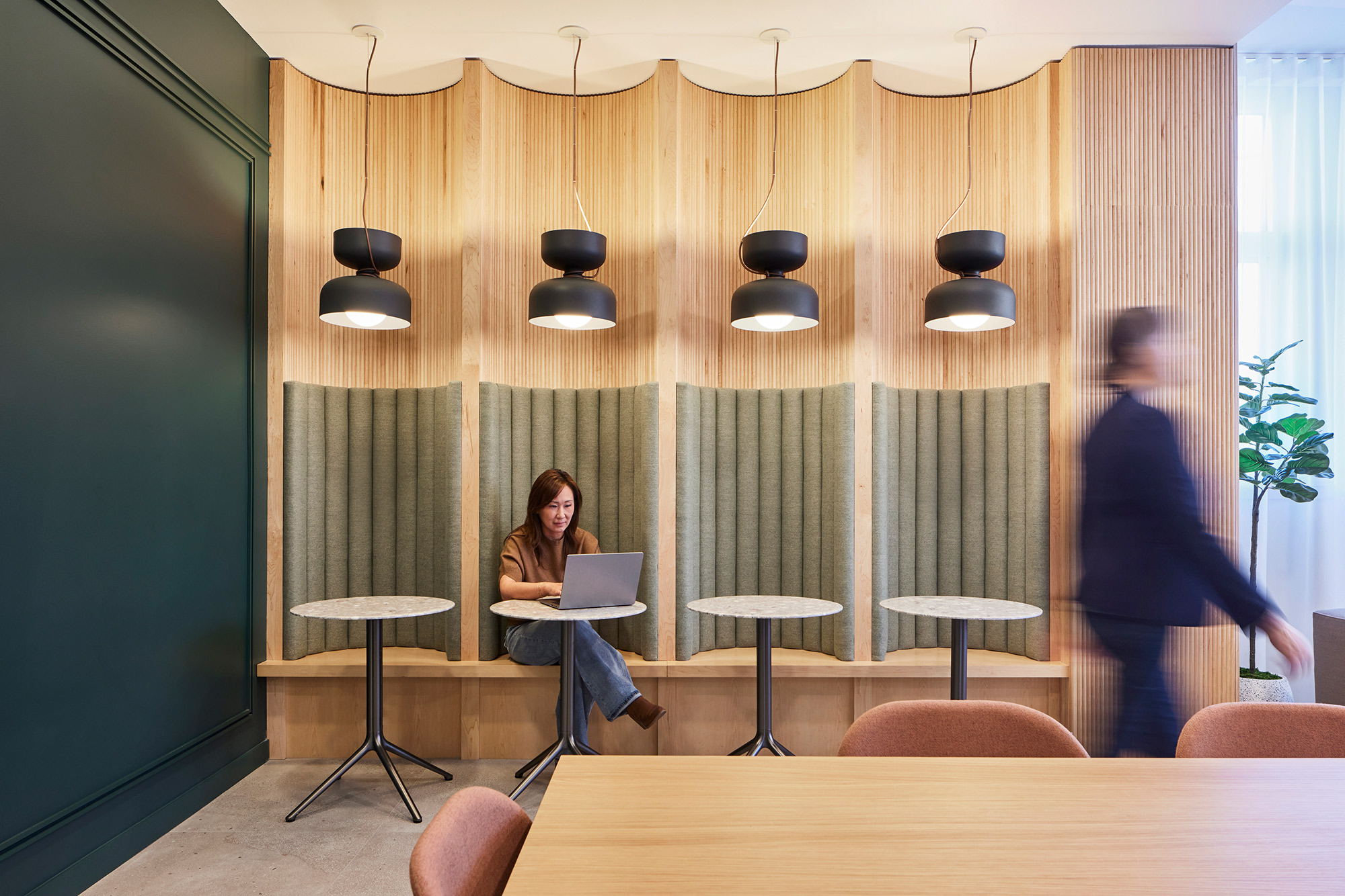 photo of the interior of basalt with a woman walking by and a woman sitting in a study area